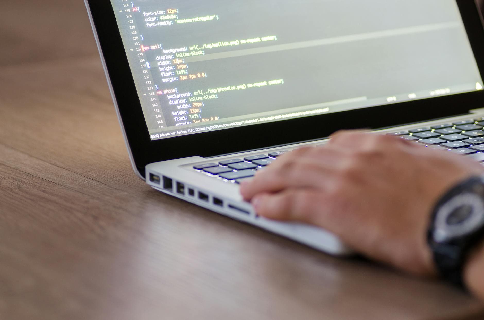 Developer at a laptop with code on screen