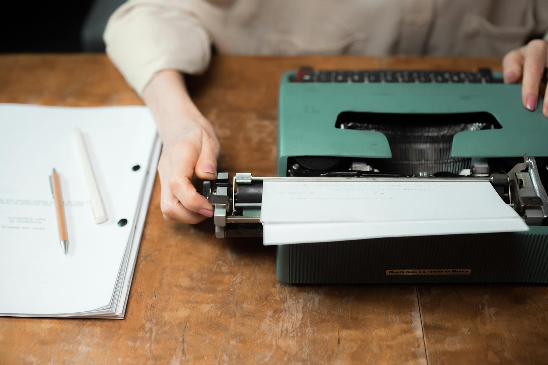 Hands typing on a vintage typewriter